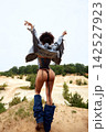 Fashionable woman with curly hair from behind in revealing denim outfit outdoors 142527923
