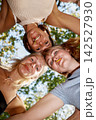 Playful young women with lollipops looking down at camera in huddle 142527930
