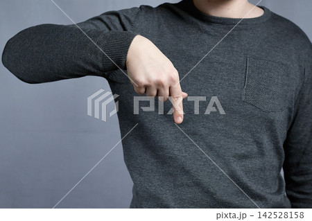 Person Pointing Down With Finger Over Gray Sweater Indicating Direction Or Selection, Casual Clothing Person Pointing Down With Finger Over Gray Sweater Indicating Direction Or Selection, Casual Clothing 142528158
