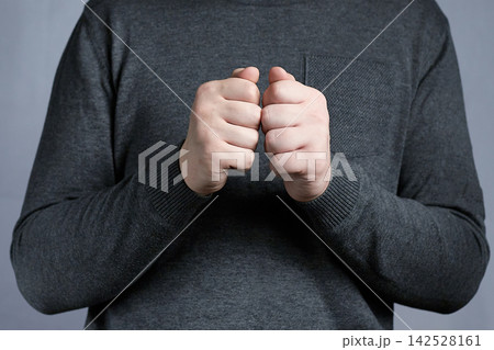 Clenched Fists Gesture Of Nervousness And Tension By Person Wearing Dark Sweater Clenched Fists Gesture Of Nervousness And Tension By Person Wearing Dark Sweater 142528161