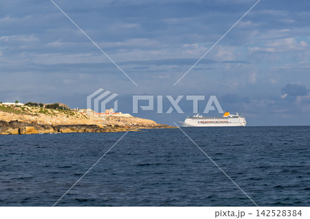 White cruise ship sailing beside rocky coastline across dark blue sea, dramatic layered clouds creating scenic maritime travel atmosphere White cruise ship sailing beside rocky coastline across dark blue sea, dramatic layered clouds creating scenic maritime travel atmosphere 142528384