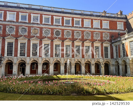 Fountain Court at Hampton Court Palace with Baroque Architecture and Blooming Tulip Garden Fountain Court at Hampton Court Palace with Baroque Architecture and Blooming Tulip Garden 142529530
