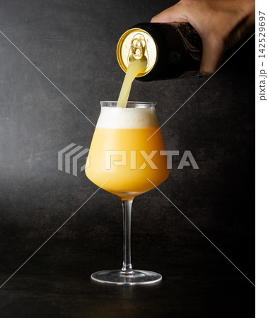 缶からグラスへ注がれる濁りのあるアメリカン・クラフトビール、ヘイジーIPAのイメージ 缶からグラスへ注がれる濁りのあるアメリカン・クラフトビール、ヘイジーIPAのイメージ 142529697