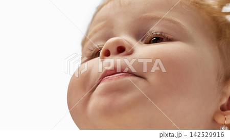 Low angle close-up portrait of toddler girl looking up. Low angle close-up portrait of toddler girl looking up. 142529916