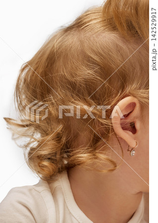 Close-up of toddler girl ear and curly blonde hair. 142529917