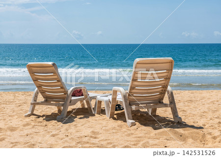 white plastic lounge chairs on Baan Krood sandy beach, Prachuap white plastic lounge chairs on Baan Krood sandy beach, Prachuap 142531526