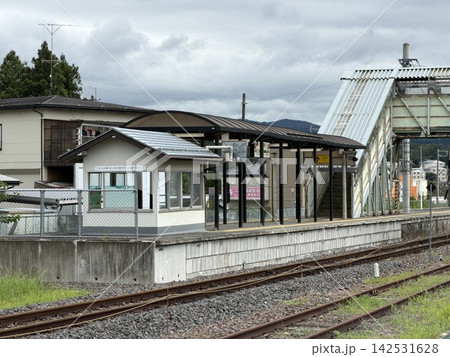 曇り空の地方駅ホームと跨線橋のあるローカル線風景 曇り空の地方駅ホームと跨線橋のあるローカル線風景 142531628
