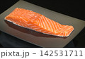 Fresh raw salmon fillet portion neatly served on sleek black rectangular plate, premium Japanese sashimi seafood delicacy 142531711
