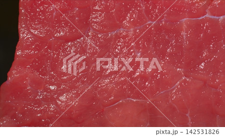 Extreme macro shot of fresh raw beef meat surface, glistening red muscle fibers and fine connective tissue texture 142531826