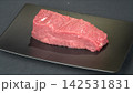 Prime cut fresh raw beef tenderloin steak portion served on modern black rectangular plate, gourmet culinary ingredient 142531831