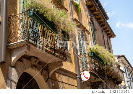 Wrought Iron Balcony with Potted Plants on Historic Building Facade in Verona Old Town Center Italy 142533143