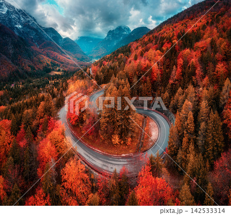 Aerial view of winding mountain road in forest at sunset. Autumn Aerial view of winding mountain road in forest at sunset. Autumn 142533314
