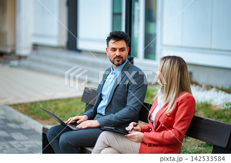 Business people having outdoor discussion using technology 142533584