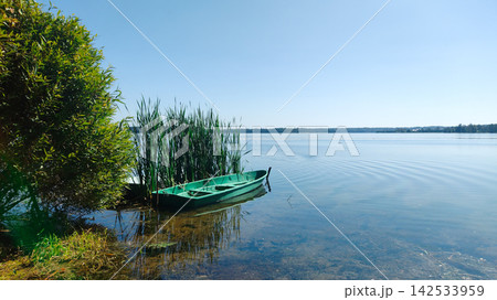 A row of small boats are docked at the shore A row of small boats are docked at the shore 142533959