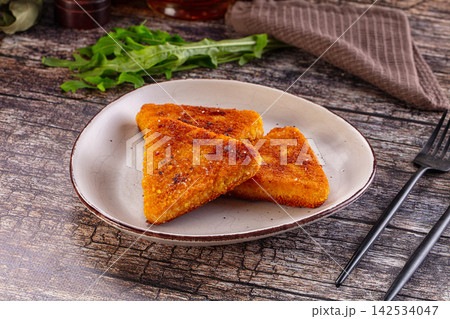 Crispy breaded fish fillets on ceramic plate with arugula and rustic wood background Crispy breaded fish fillets on ceramic plate with arugula and rustic wood background 142534047