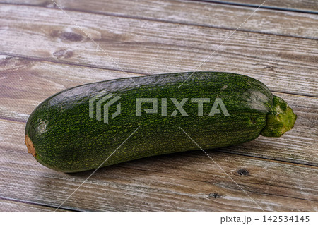 Fresh green zucchini on a rustic wooden table background Fresh green zucchini on a rustic wooden table background 142534145