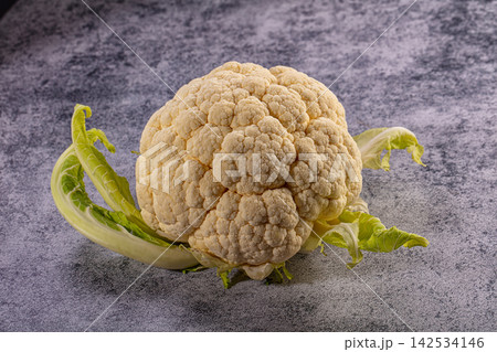 Fresh whole cauliflower head with leaves on a textured gray background 142534146