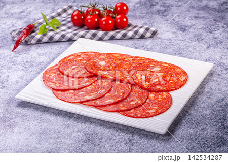 Sliced chorizo on white plate with cherry tomatoes and red chili pepper Sliced chorizo on white plate with cherry tomatoes and red chili pepper 142534287