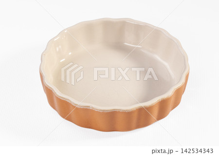 Empty ceramic tart pan with fluted edges on white background Empty ceramic tart pan with fluted edges on white background 142534343