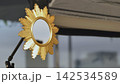 Golden sunburst mirror reflecting room details and studio equipment 142534589