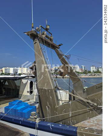 Fishing vessel stern gantry with net frame and stacked blue fish crates on the deck Fishing vessel stern gantry with net frame and stacked blue fish crates on the deck 142534902