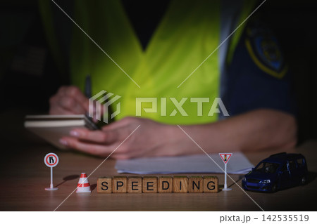 Traffic enforcement officer documenting a speeding incident at night 142535519