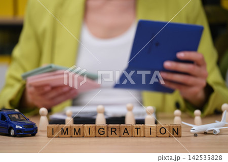 Exploring immigration services with a tablet and model vehicles on a wooden desk Exploring immigration services with a tablet and model vehicles on a wooden desk 142535828
