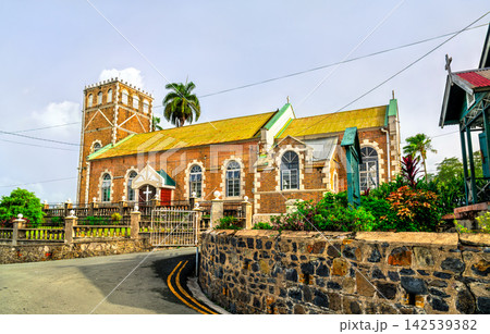 Exterior view of Holy Trinity Anglican Church with red brick walls and stone wall in Castries, Saint Lucia. 142539382