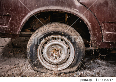 A leaky tire and a flat of an old car with dust and dirt on it. vintage car A leaky tire and a flat of an old car with dust and dirt on it. vintage car 142540047