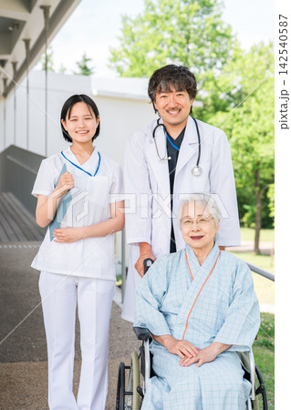 病院の廊下で車椅子のシニア入院患者に付き添う医師と看護師 病院の廊下で車椅子のシニア入院患者に付き添う医師と看護師 142540587