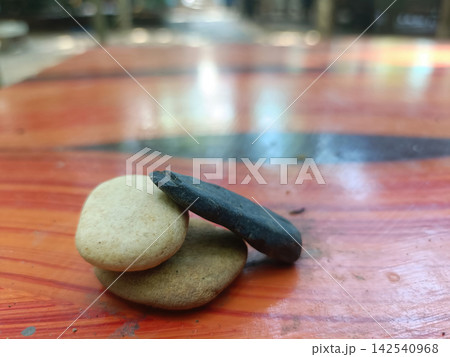 Brown stone stack on polished wooden table with blurred background and soft light 142540968