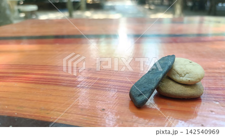 Stacked stone and dark pebble on polished wooden table 142540969