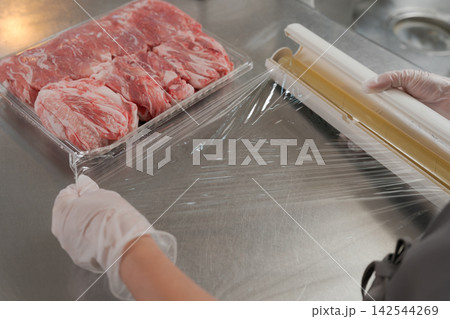 大量のお肉を小分けする女性の手元 142544269