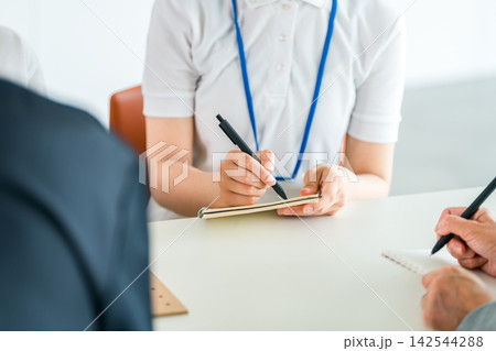 研修や勉強会で話を聞きながらノートにメモを取る女性の手元 142544288