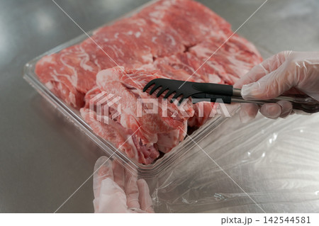 大量のお肉を小分けする女性の手元 大量のお肉を小分けする女性の手元 142544581
