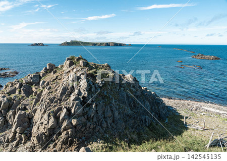 北海道礼文島のスコトン岬の荒々しい岩山越しに望む青い海と海驢島 142545135