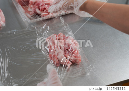 大量のお肉を小分けする女性の手元 142545311