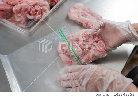 大量の豚肉を小分けする女性の手元 大量の豚肉を小分けする女性の手元 142545555
