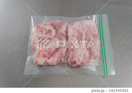 大量の豚肉を小分けする女性の手元 142545561