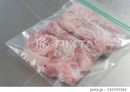 大量の豚肉を小分けする女性の手元 142545562