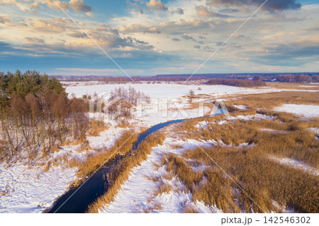 Rural landscape in winter. View from above of forest and brook on the meadow. Nature background 142546302