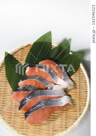 新鮮な鮭の切り身を竹ざるに並べた日本の食材写真。 新鮮な鮭の切り身を竹ざるに並べた日本の食材写真。 142546323