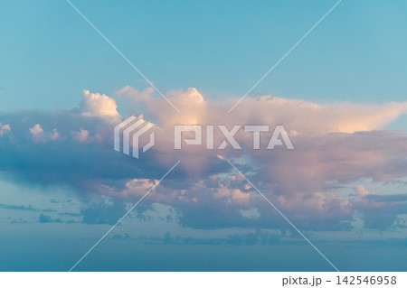 Pastel Cumulus Clouds Glowing Across Blue Sky 142546958