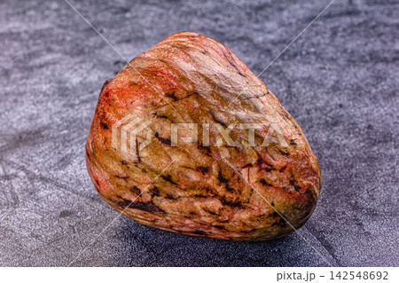 Ripe annona fruit with textured skin on dark surface Ripe annona fruit with textured skin on dark surface 142548692