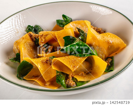 Pasta with spinach and meat in creamy sauce served in ceramic bowl Pasta with spinach and meat in creamy sauce served in ceramic bowl 142548719