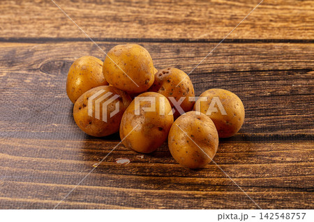Fresh raw potatoes on rustic wooden surface 142548757