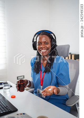 Nurse providing telemedicine holding pills during online consultation 142549183