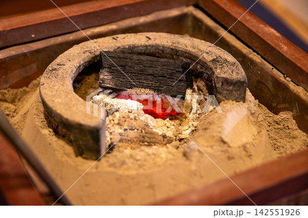 Glowing charcoal embers in traditional fire pit Glowing charcoal embers in traditional fire pit 142551926