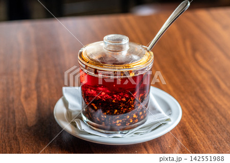 Glass mug of hot mulled wine with a spoon on a Glass mug of hot mulled wine with a spoon on a 142551988