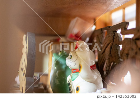 Japanese lucky cat figurine displayed on a wooden Japanese lucky cat figurine displayed on a wooden 142552002